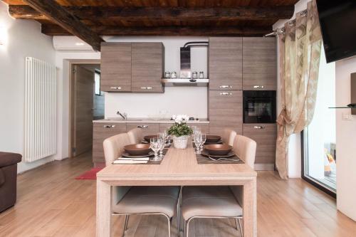 a kitchen and dining room with a wooden table and chairs at Villa Broglia House in Verona