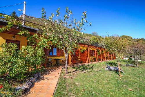 a house with a garden in front of it at Apartamentos Rurales Balcón Real Senda del Oso in Campiello