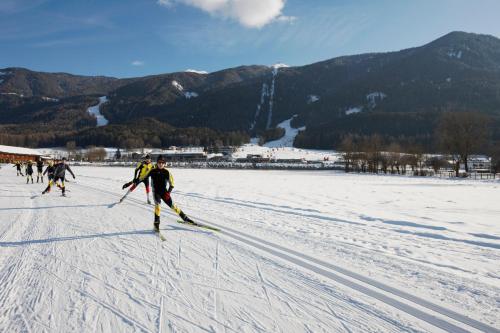 a group of people skiing in the snow at B&B Garni Schorneck in Brunico