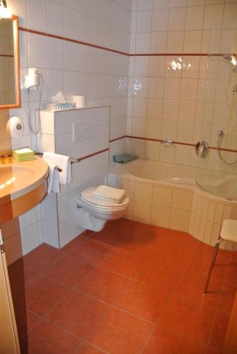 a bathroom with a toilet and a tub and a sink at Gasthof Zum Stollhofer in Inzing