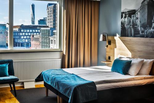 a hotel room with a bed and a large window at First Hotel Jörgen Kock in Malmö