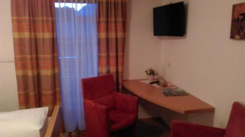 a room with a desk and a red chair at Gasthof Zum Stollhofer in Inzing