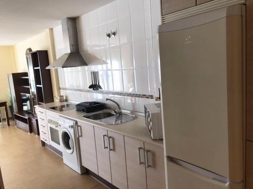 cocina con lavadora, fregadero y nevera en Apartamento La Paloma, en Las Navas del Marqués