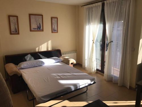 1 dormitorio con cama y ventana grande en Apartamento La Paloma, en Las Navas del Marqués