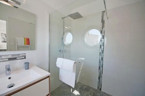 une salle de bain blanche avec une douche et un lavabo dans l'établissement La Moulinière, à Pennautier