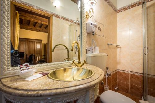 y baño con lavabo de oro y ducha. en Soggiorno Annamaria, en Florencia