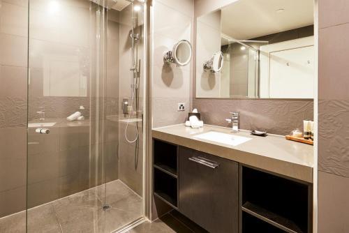 a bathroom with a shower and a sink at The Sebel Melbourne Flinders Lane in Melbourne