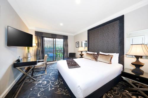 a hotel room with a bed and a flat screen tv at The Sebel Melbourne Flinders Lane in Melbourne