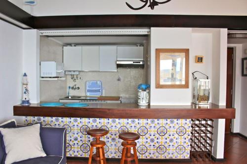 a kitchen with a bar with a counter top at Akisol Sesimbra Beach in Sesimbra