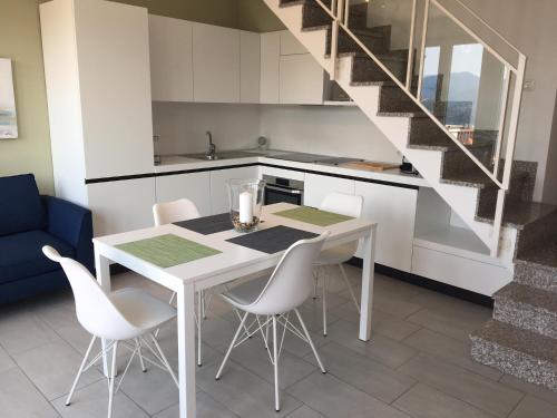 a kitchen with a white table and white chairs at Tower 44 in Luino