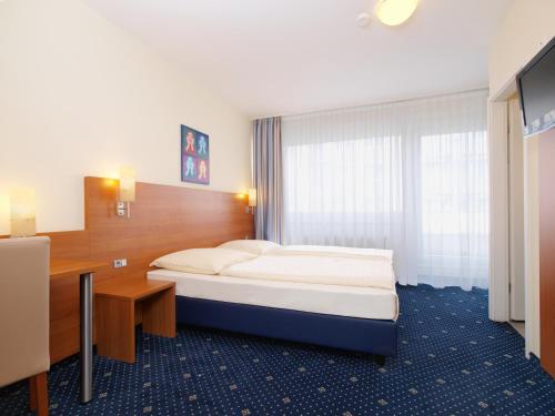 Habitación de hotel con cama y escritorio en Callas am Dom en Colonia