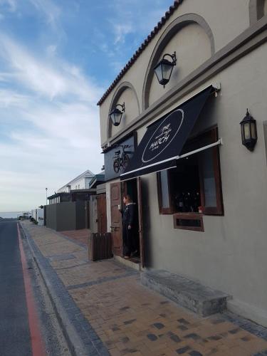 a person standing outside of a building with an umbrella at 210 Atlantic Sun in Bloubergstrand