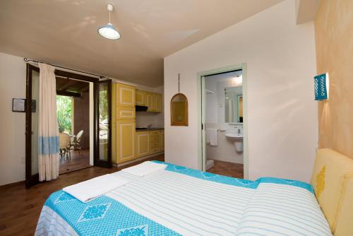 a bedroom with a bed and a bathroom at Residence S'incantu in Villasimius