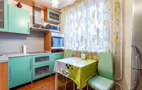 モスクワにあるFortEstate Apartment Nametkina 9のキッチン(青いキャビネット、テーブル、椅子付)