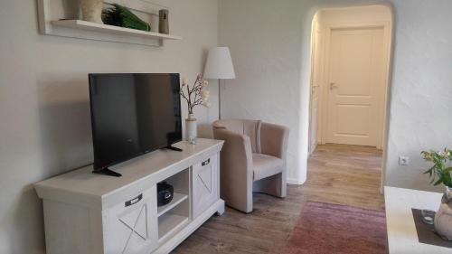 a living room with a flat screen tv on a entertainment center at Maifeld-Fewo Sonnenschein in Kerben