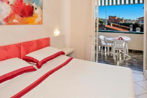 a bedroom with a bed and a balcony with a table at Blue Lake Residence - Bardolino in Bardolino