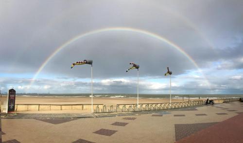 a rainbow in the sky over a beach at B&B Aquavit in Knokke-Heist