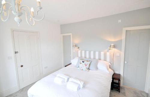 a bedroom with a white bed with towels on it at Poplars Farm in Henlow