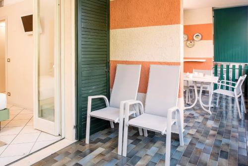 d'une terrasse avec des chaises blanches et une table. dans l'établissement Blue Lake Residence - Bardolino, à Bardolino