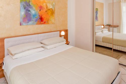a bedroom with a white bed and a mirror at Blue Lake Residence - Bardolino in Bardolino
