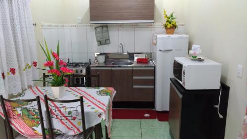 グラマドにあるSossego da Casa Vermelhaの小さなキッチン(テーブル、白い冷蔵庫付)