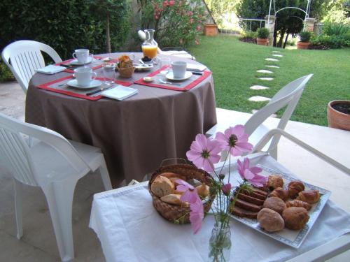 een tafel met een mand met eten en bloemen erop bij Chambres d'Hôtes Les Jardins de la Cathédrale in Angoulême