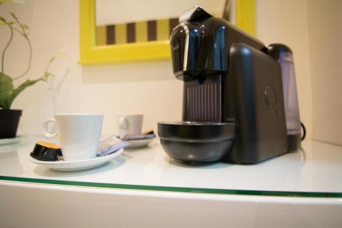 a coffee maker and a cup on a counter at Hostal Paris in San Fernando