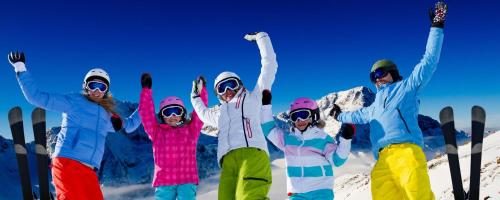 un grupo de personas de pie en la nieve con sus brazos en el aire en Apartmány Riviéra a Chalupa Riviéra Liptov, Bešeňová, en Bešeňová