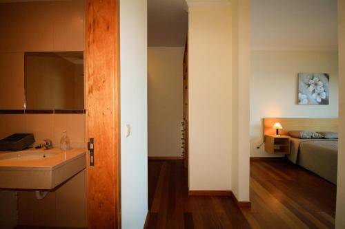 1 dormitorio con 1 cama y baño con lavabo. en Paradise Ocean View by AnaLodges, en Porto Moniz