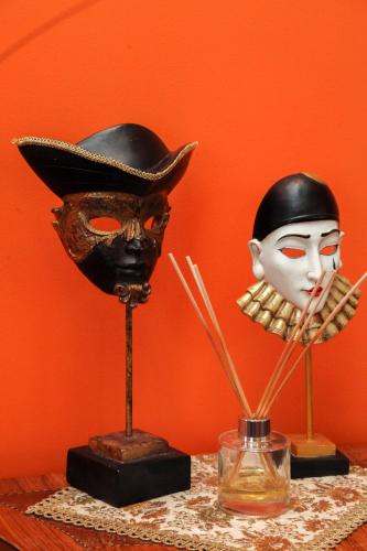twoumed masks and a hat on a table at Pažaislis Park Hotel in Kaunas