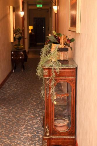 a wooden cabinet with plants on it in a hallway at Pažaislis Park Hotel in Kaunas