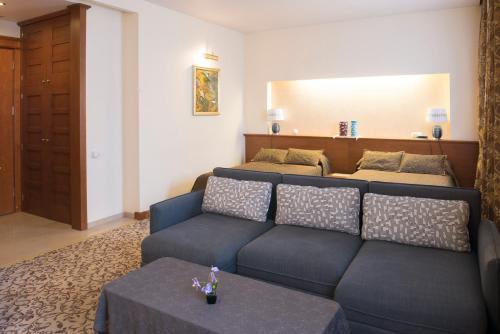a living room with a blue couch and a table at Pažaislis Park Hotel in Kaunas