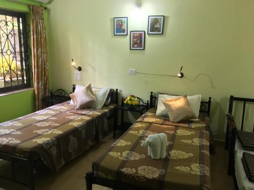 a room with two beds and a window at John's Highland Comfort (Guest House) in Majorda