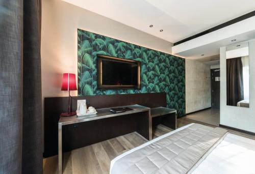 a bedroom with a bed and a tv on a wall at Hotel Manin in Milan