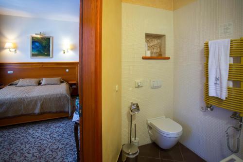 a bathroom with a bed and a toilet in a room at Pažaislis Park Hotel in Kaunas