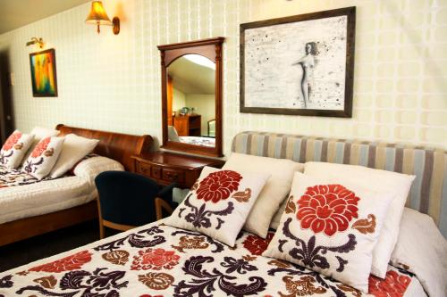 Schlafzimmer mit einem Bett und einem Spiegel sowie einem Bett mit Kissen in der Unterkunft Pažaislis Park Hotel in Kaunas