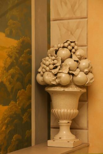 a vase filled with onions sitting on a shelf next to a painting at Pažaislis Park Hotel in Kaunas