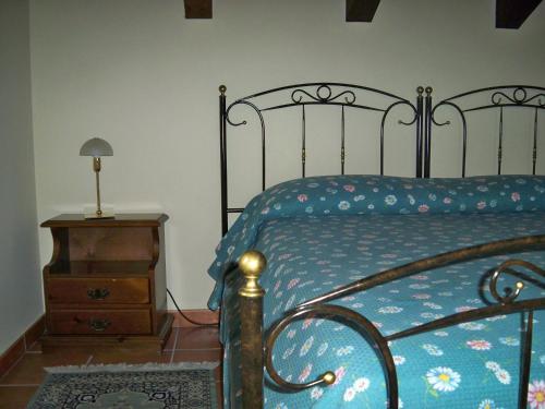 a bedroom with a bed and a wooden nightstand with a blue bedspread at Difesa del Principe in Felitto