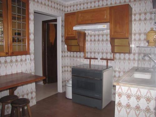 a kitchen with a sink and a stove top oven at Casa em Passa Quatro in Passa Quatro