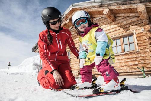 a man and a child on skis in front of a cabin at Ferienwohnung Schrofamühli in Silbertal