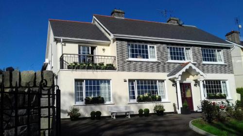 a white house with a bench in front of it at Nordav Guesthouse in Clonakilty