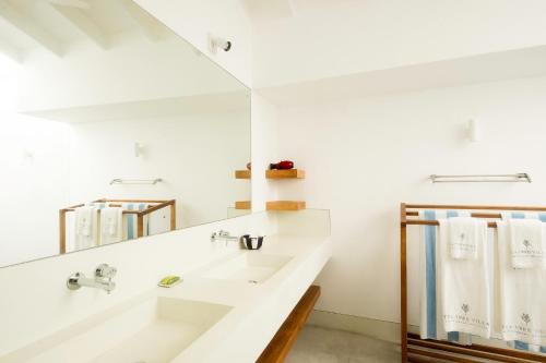 a white bathroom with a sink and a mirror at Tea Tree Villa in Ahangama