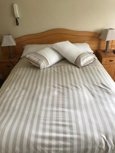 a bed with two pillows on top of it at Derreen Tighue House in Tralee