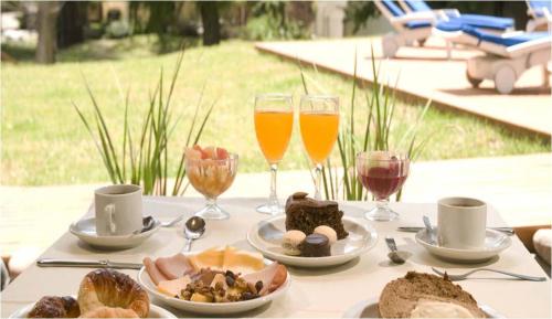 una mesa con platos de comida y copas de vino en Terrazas Club Hotel, en Villa Gesell