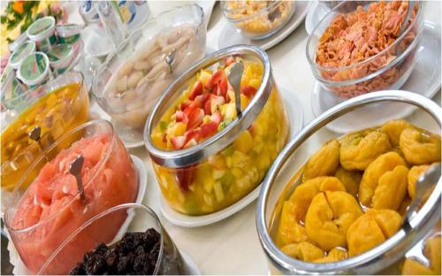 una mesa cubierta con recipientes de diferentes tipos de alimentos en Terrazas Club Hotel, en Villa Gesell