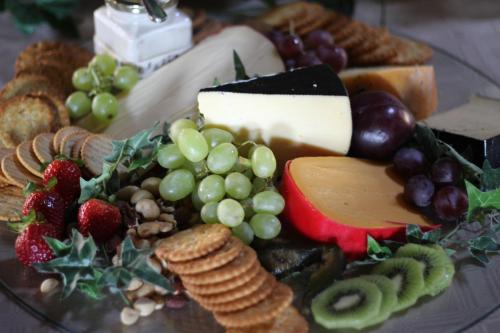 Un plato de comida con queso, frutas y galletas. en Oranje Guest Farm, en Fouriesburg