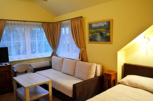 a living room with a couch in front of a window at Vila Liepa in Birštonas