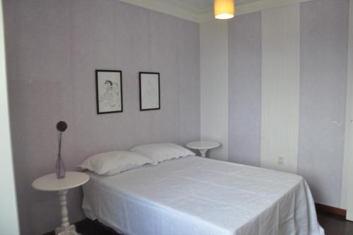 1 dormitorio con 1 cama blanca y 2 mesas en 3 Quartos na Praia do Buracão - Rio Vermelho, en Salvador