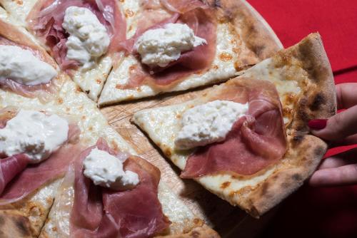 a pizza with ham and cheese on a table at Hotel Viest in Vicenza
