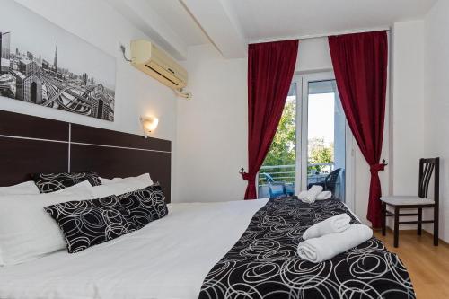 a bedroom with a bed with two towels on it at Villa Veron in Ohrid
